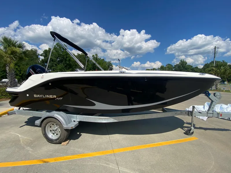 Slide: The Image of 2024 Bayliner Element M19 boat on trailer under clear blue sky. - 1