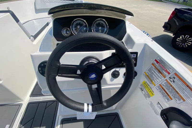 Slide: The Image of 2024 Bayliner Element M19 boat dashboard with steering wheel and gauges. - 7