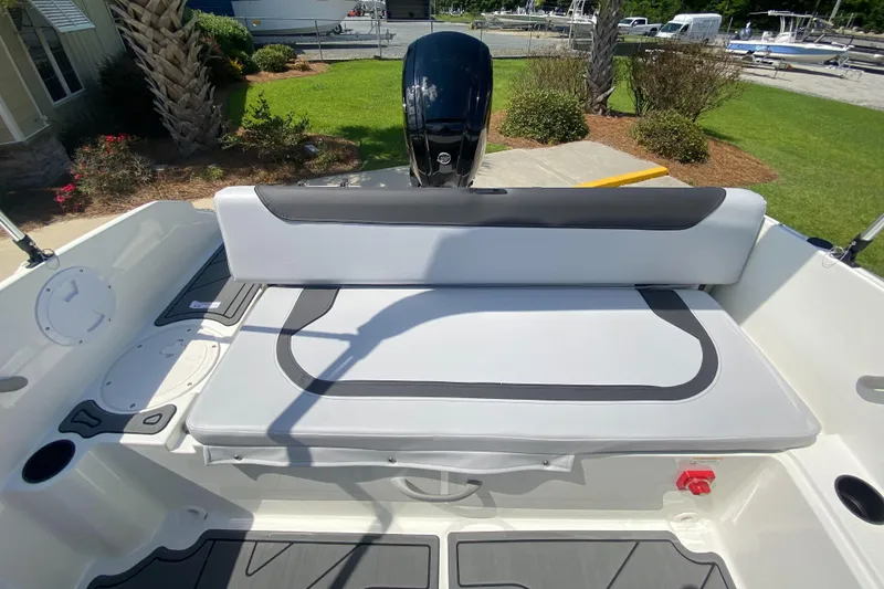 Slide: The Image of 2024 Bayliner Element M19 boat interior with cushioned seating and outboard motor. - 10