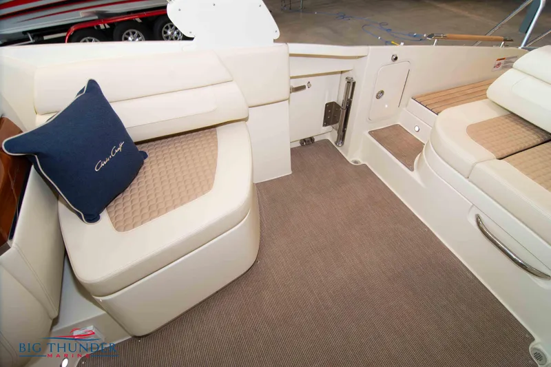 Slide: The Image of 2023 Chris-Craft Launch 31 GT interior seating area with beige upholstery and blue cushion. - 26