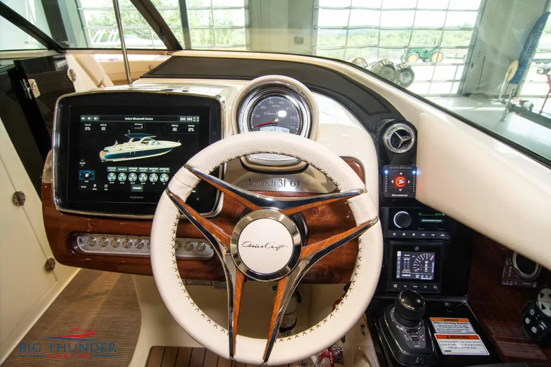 Slide: The Image of 2023 Chris-Craft Launch 31 GT boat dashboard with steering wheel and digital display. - 34