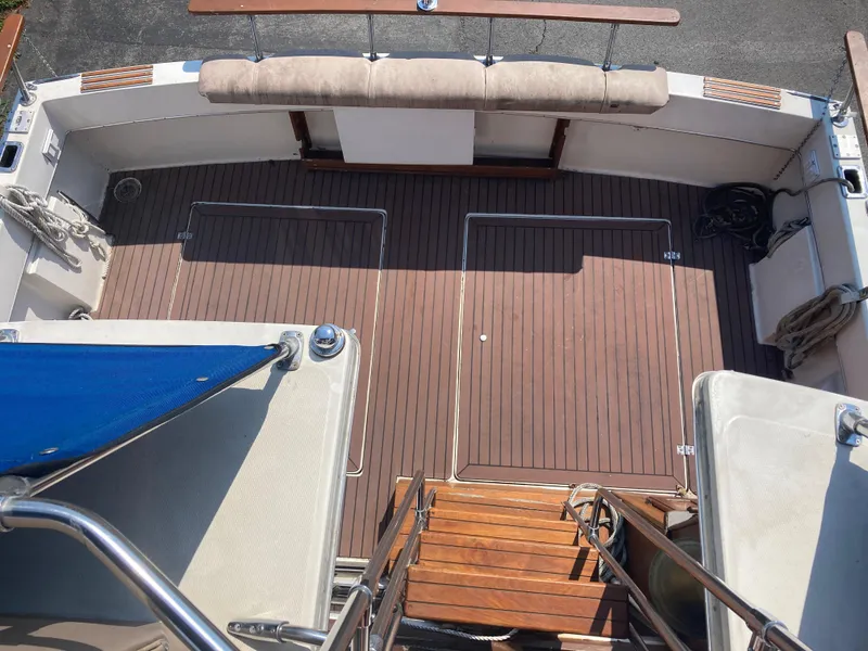 Slide: The Image of 1984 Bayliner 3270 Command Bridge boat deck with wooden flooring and cushioned seating. - 10