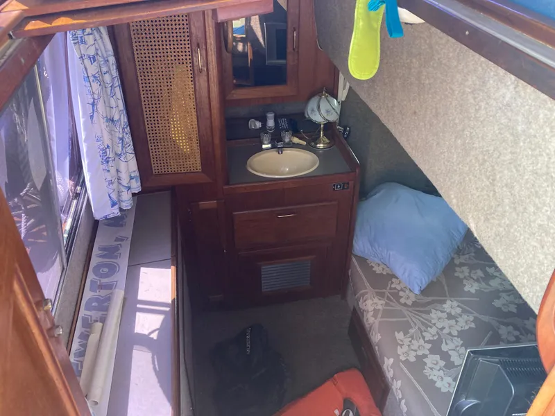Slide: The Image of 1984 Bayliner 3270 Command Bridge cabin interior with sink and bed. - 11