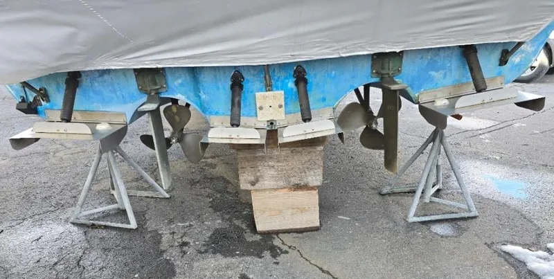 Slide: The Image of 1984 Bayliner 3270 Command Bridge boat on stands, showing propellers and rudders. - 19