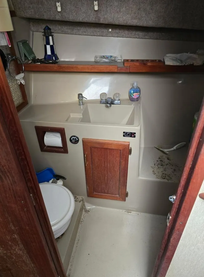 Slide: The Image of 1984 Bayliner 3270 Command Bridge bathroom with sink, toilet, and wooden cabinet. - 20