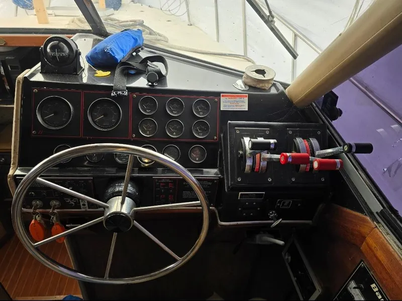 Slide: The Image of 1984 Bayliner 3270 Command Bridge helm with steering wheel and control panel. - 26