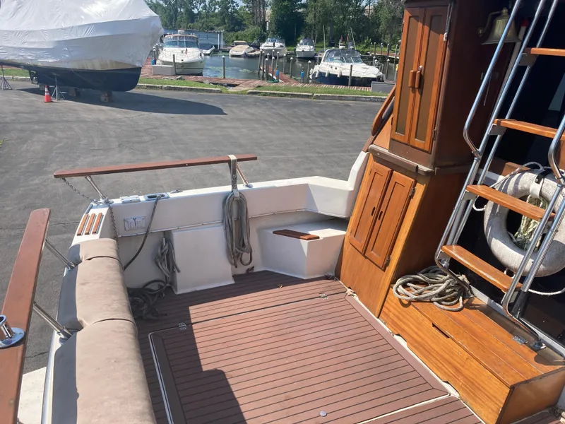 Slide: The Image of 1984 Bayliner 3270 Command Bridge boat deck with wooden flooring and storage cabinets. - 6
