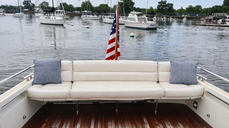 Slide: The Image of 2010 MJM 40z Downeast boat with white seating and American flag in a marina. - 16