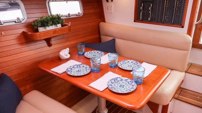 Slide: The Image of Elegant dining area inside a 2010 MJM 40z Downeast boat with wooden table and cushioned seating. - 18