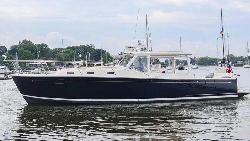 Slide: The Image of 2010 MJM 40z Downeast boat on calm water with marina background. - 2