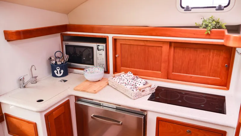 Slide: The Image of 2010 MJM 40z Downeast yacht kitchen with microwave, stove, and wooden cabinets. - 20