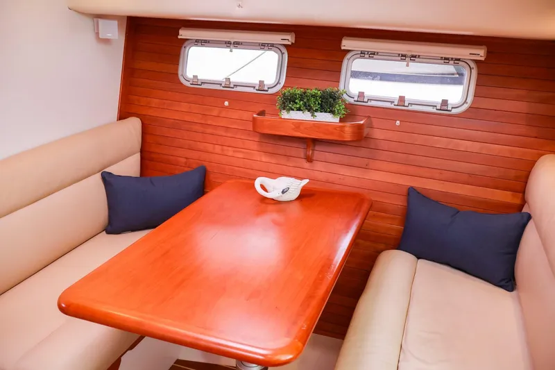Slide: The Image of Interior dining area of 2010 MJM 40z Downeast yacht with wooden table and beige seating. - 22