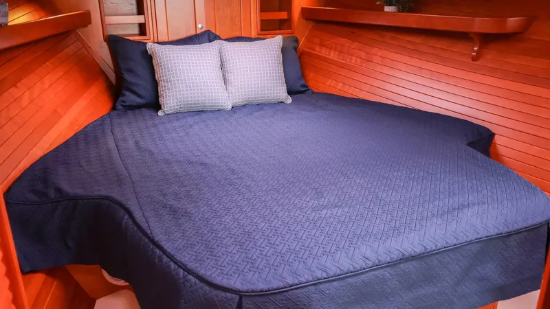 Slide: The Image of 2010 MJM 40z Downeast boat cabin with blue bedding and wooden interior. - 26