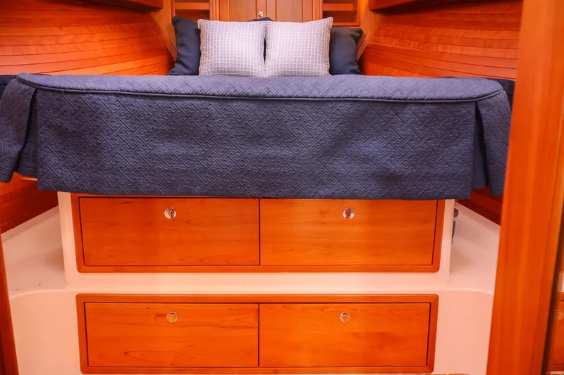 Slide: The Image of 2010 MJM 40z Downeast boat cabin with blue bedding and wooden drawers. - 27