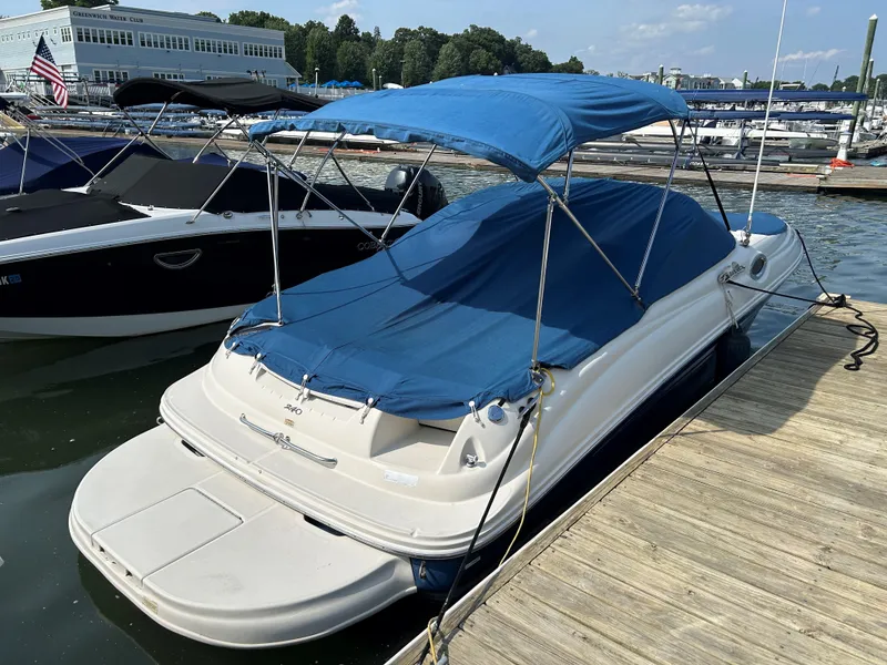 Slide: The Image of 2007 Sea Ray 240 Sundeck boat docked with blue canopy and cover. - 11