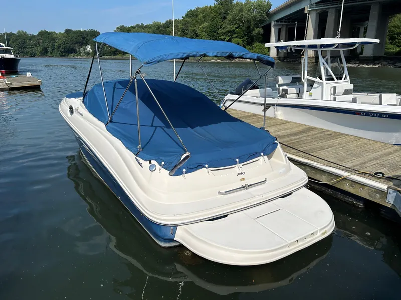 Slide: The Image of 2007 Sea Ray 240 Sundeck boat docked with blue canopy and cover. - 12