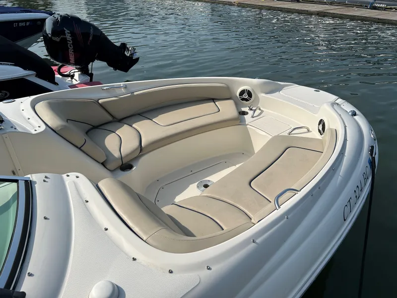 Slide: The Image of 2007 Sea Ray 240 Sundeck boat with beige seating, docked on calm water. - 4