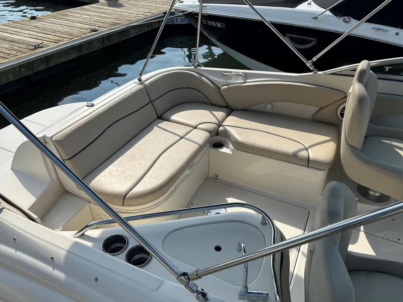 Slide: The Image of 2007 Sea Ray 240 Sundeck interior with beige seating and cup holders. - 6