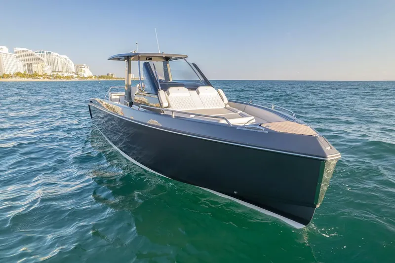 Slide: The Image of Schaefer V33 2025 luxury boat cruising near a coastal city skyline. - 34