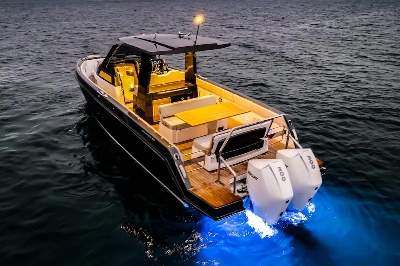 Slide: The Image of 2025 Schaefer V33 boat with dual outboard motors and illuminated deck on the water. - 32