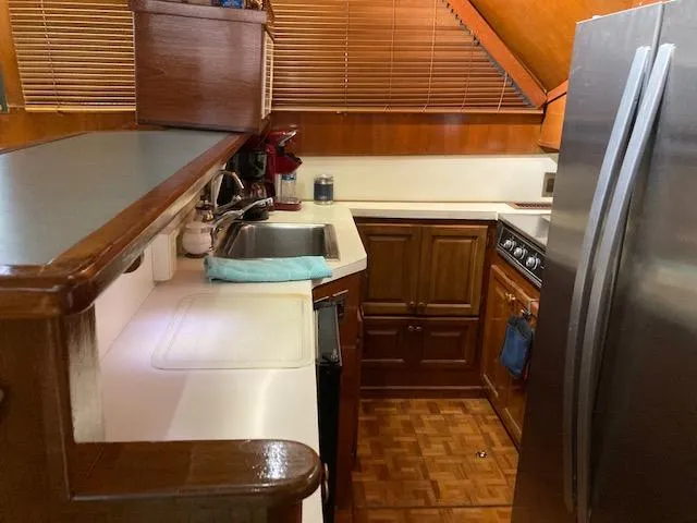 Slide: The Image of 1987 Viking Convertible boat kitchen with wooden cabinets and stainless steel appliances. - 15