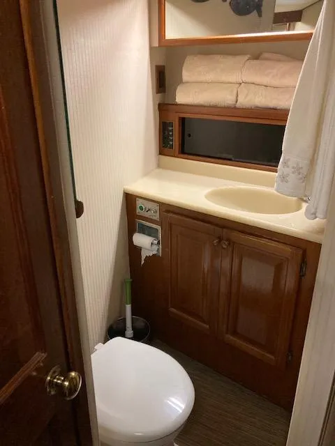 Slide: The Image of 1987 Viking Convertible boat bathroom with wooden cabinets and white fixtures. - 17