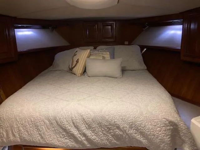 Slide: The Image of 1987 Viking Convertible boat cabin with a cozy bed and pillows. - 20