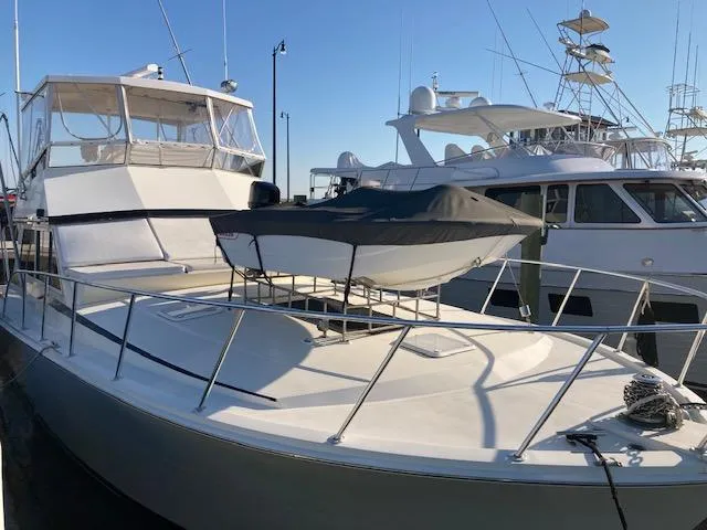 Slide: The Image of 1987 Viking Convertible yacht docked at marina with covered dinghy on deck. - 4