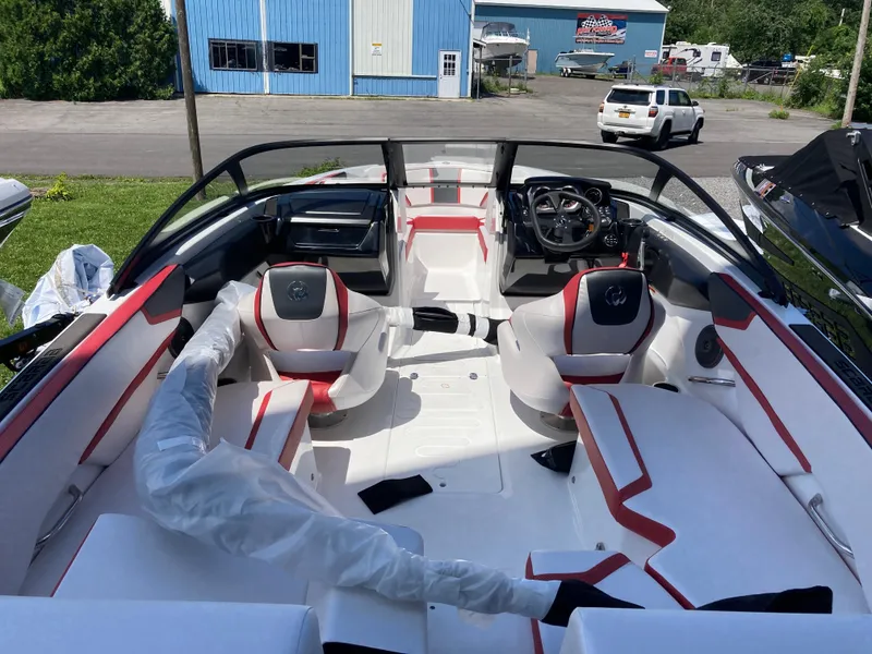 Slide: The Image of 2024 Scarab 215 boat interior with red and white seating, steering wheel, and dashboard. - 3