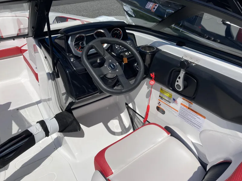 Slide: The Image of 2024 Scarab 215 boat cockpit with steering wheel and control panel. - 7