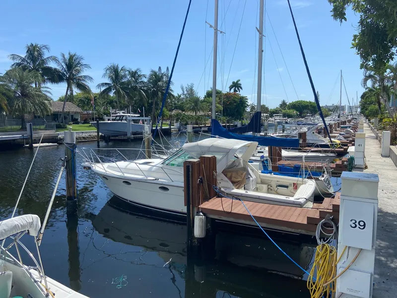 Slide: The Image of 1992 Tiara Yachts 31 Open docked at a marina with palm trees in the background. - 0
