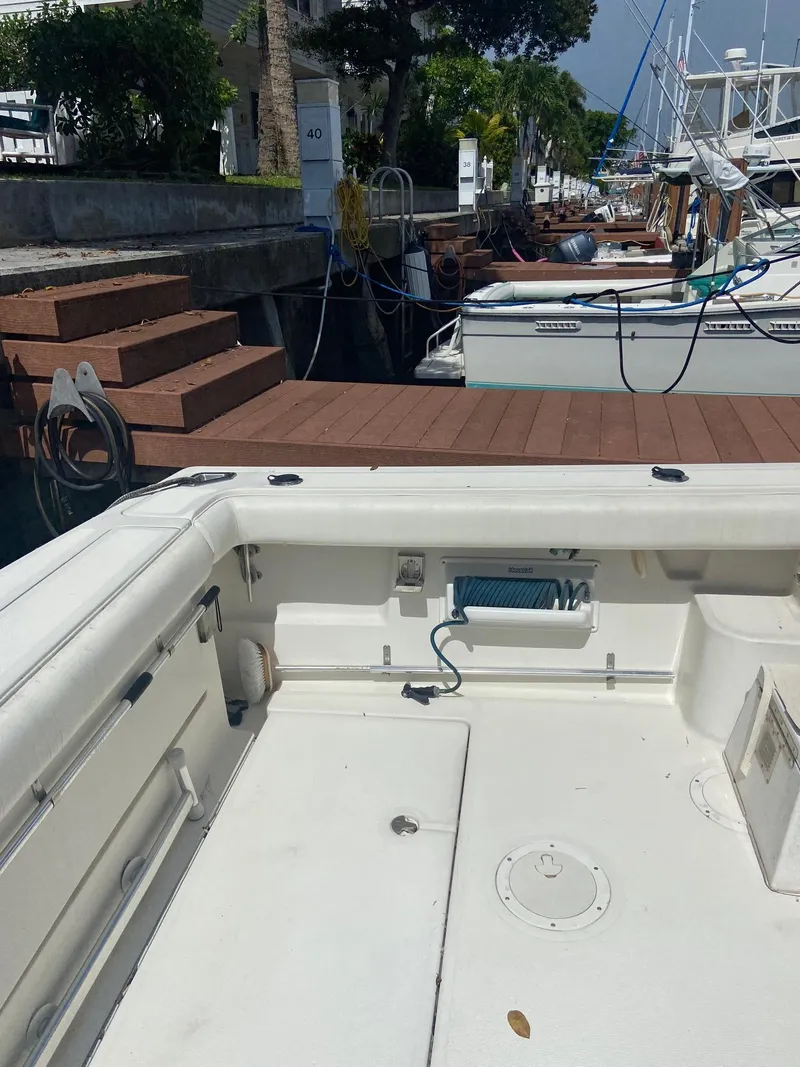 Slide: The Image of 1992 Tiara Yachts 31 Open docked at a marina, view of the deck and surrounding boats. - 11