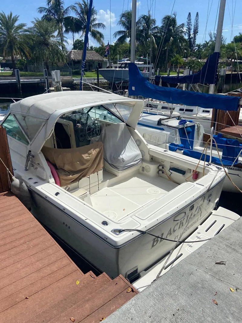 Slide: The Image of 1992 Tiara Yachts 31 Open docked at a marina with sailboats. - 2