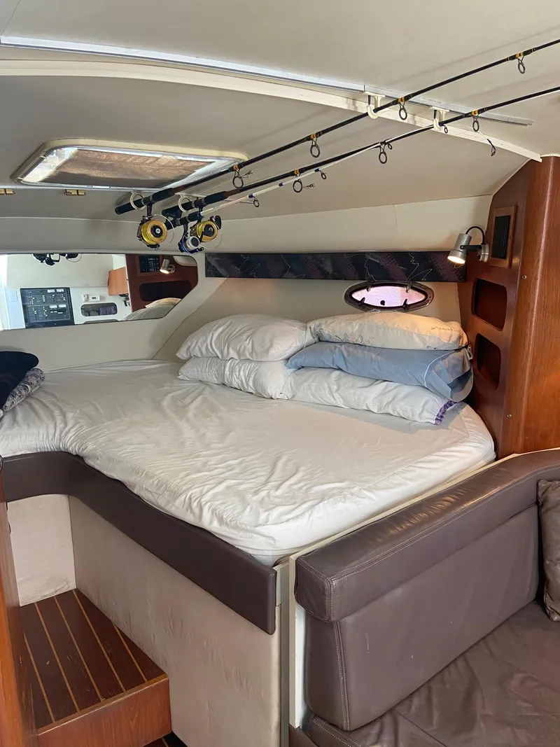 Slide: The Image of 1992 Tiara Yachts 31 Open cabin interior with bed and fishing rods. - 25