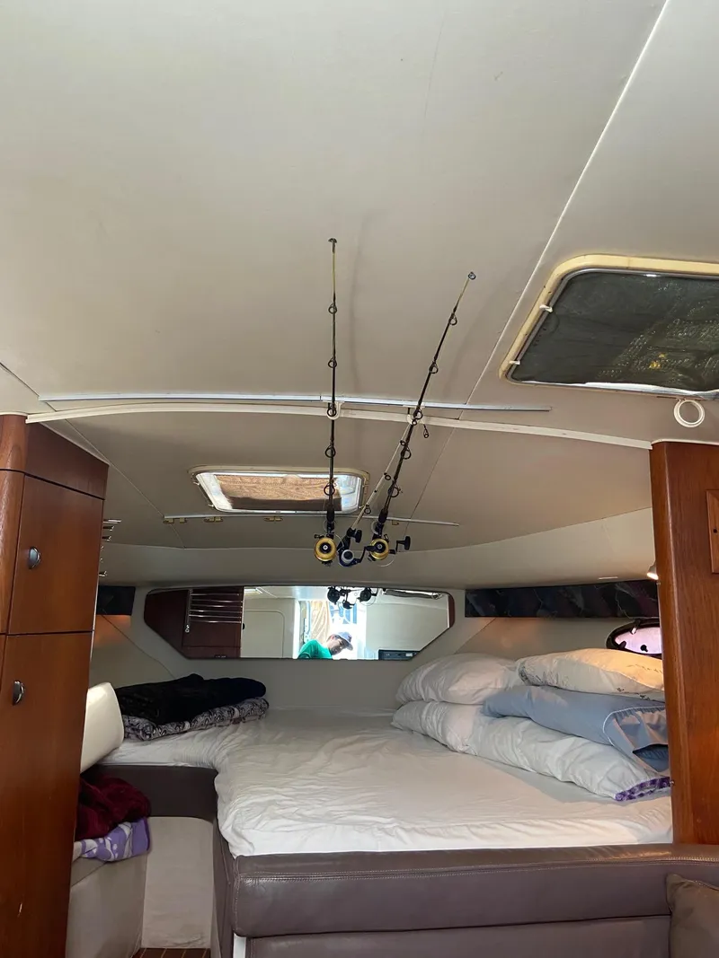 Slide: The Image of Interior cabin of a 1992 Tiara Yachts 31 Open with fishing rods and bedding. - 28