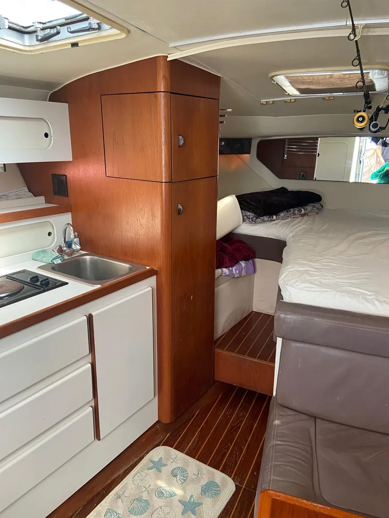 Slide: The Image of 1992 Tiara Yachts 31 Open interior with kitchen, bed, and wooden cabinetry. - 29