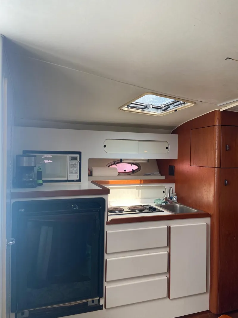 Slide: The Image of 1992 Tiara Yachts 31 Open kitchen area with microwave, sink, and storage cabinets. - 31