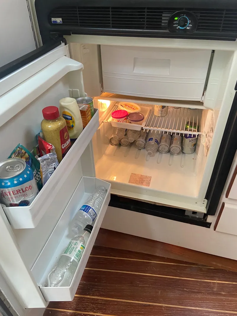 Slide: The Image of Open refrigerator inside a 1992 Tiara Yachts 31 Open, stocked with drinks and condiments. - 33