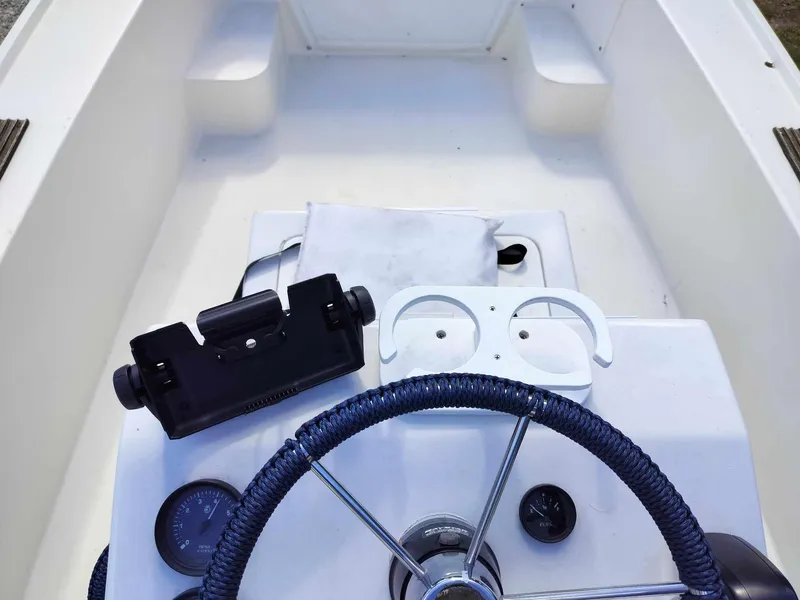Slide: The Image of 1988 Mako 171 Center Console boat dashboard with steering wheel and instrument panel. - 32