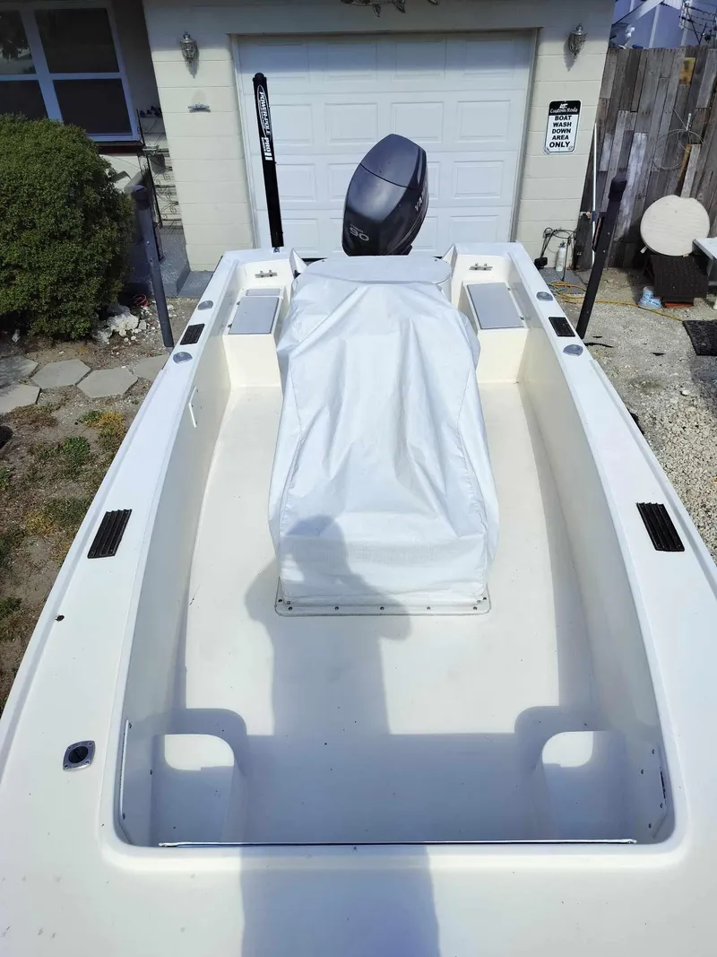 Slide: The Image of 1988 Mako 171 Center Console boat with covered console, parked in front of a garage. - 40