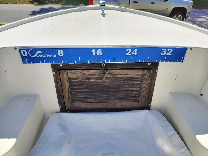 Slide: The Image of 1988 Mako 171 Center Console boat with a fish measuring ruler. - 49