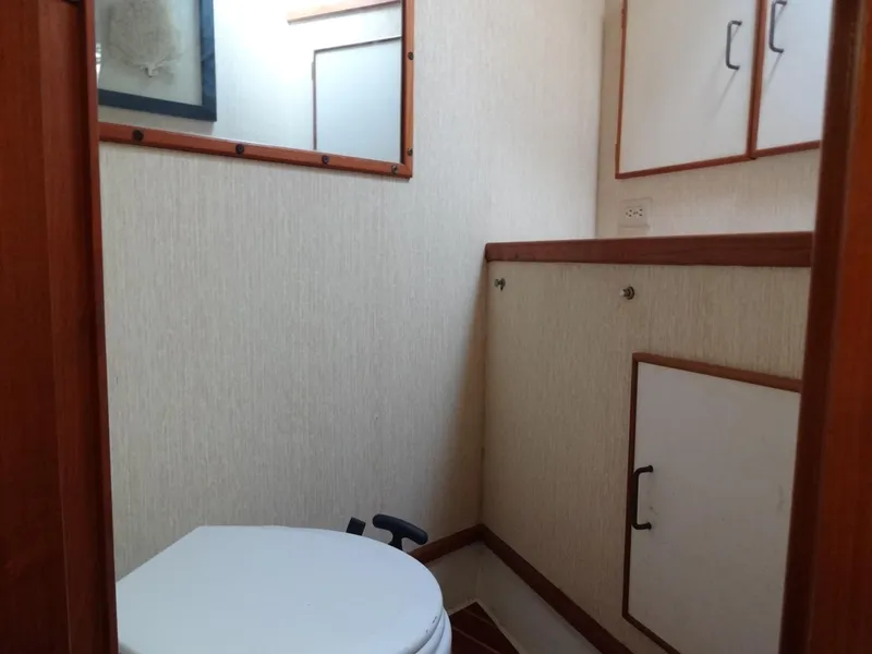 Slide: The Image of 1986 Tollycraft 44 CPMY yacht bathroom with toilet and storage cabinets. - 11