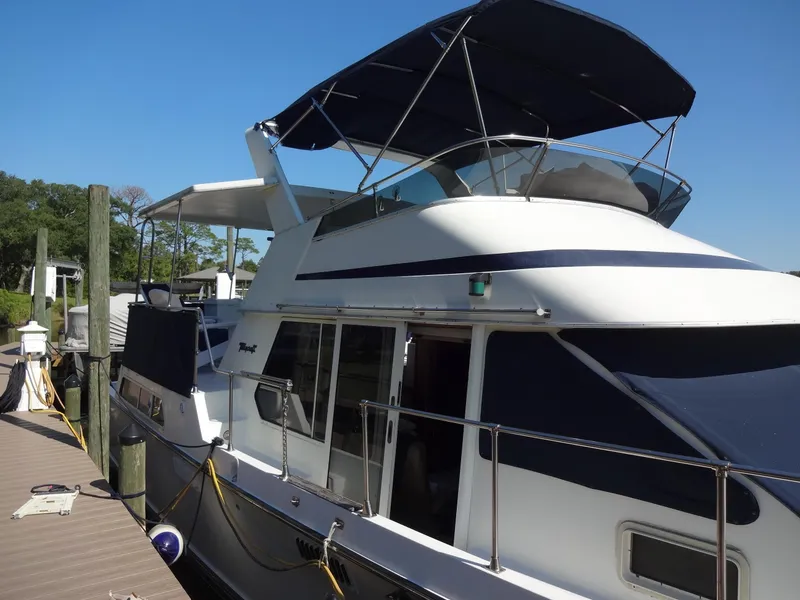 Slide: The Image of 1986 Tollycraft 44 CPMY yacht docked, featuring a sleek design and spacious deck. - 17
