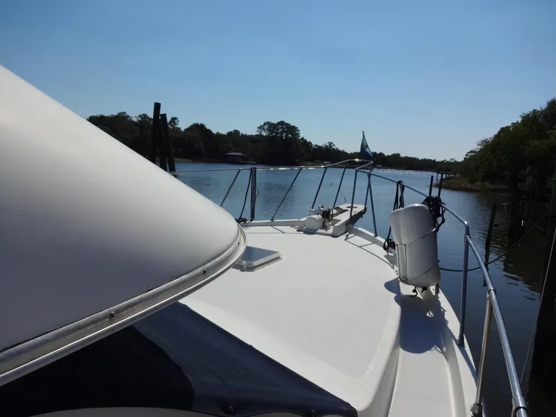 Slide: The Image of 1986 Tollycraft 44 CPMY yacht on a serene river, clear sky. - 22