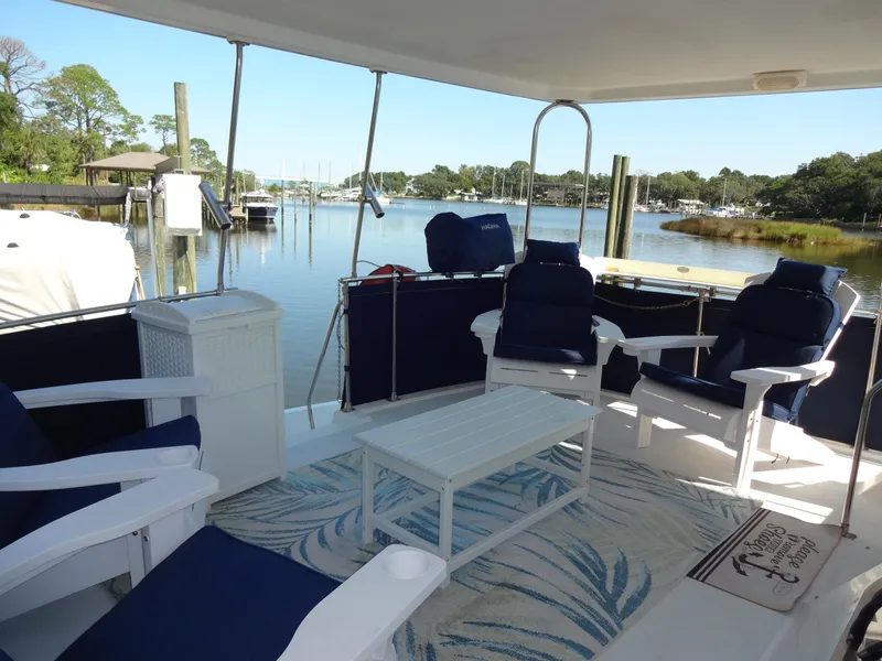 Slide: The Image of 1986 Tollycraft 44 CPMY yacht deck with seating, table, and scenic marina view. - 27