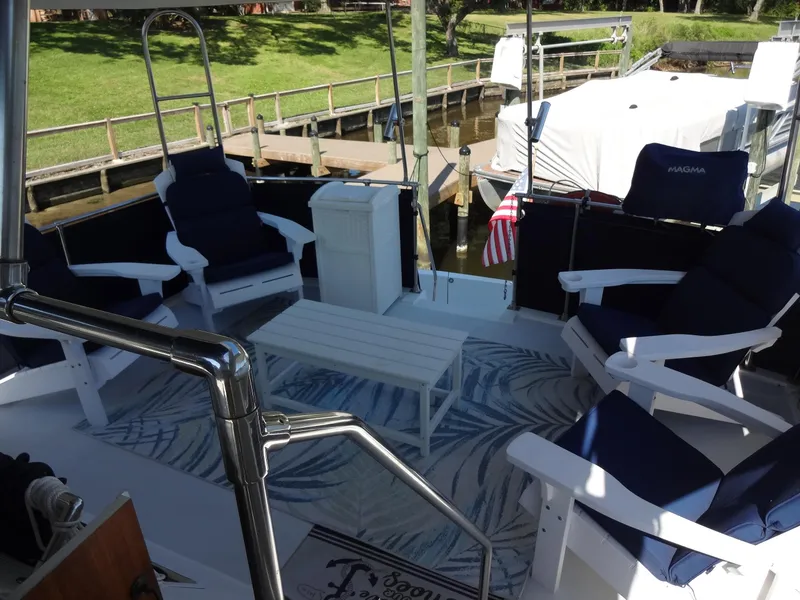 Slide: The Image of 1986 Tollycraft 44 CPMY yacht deck with seating, table, and American flag. - 38