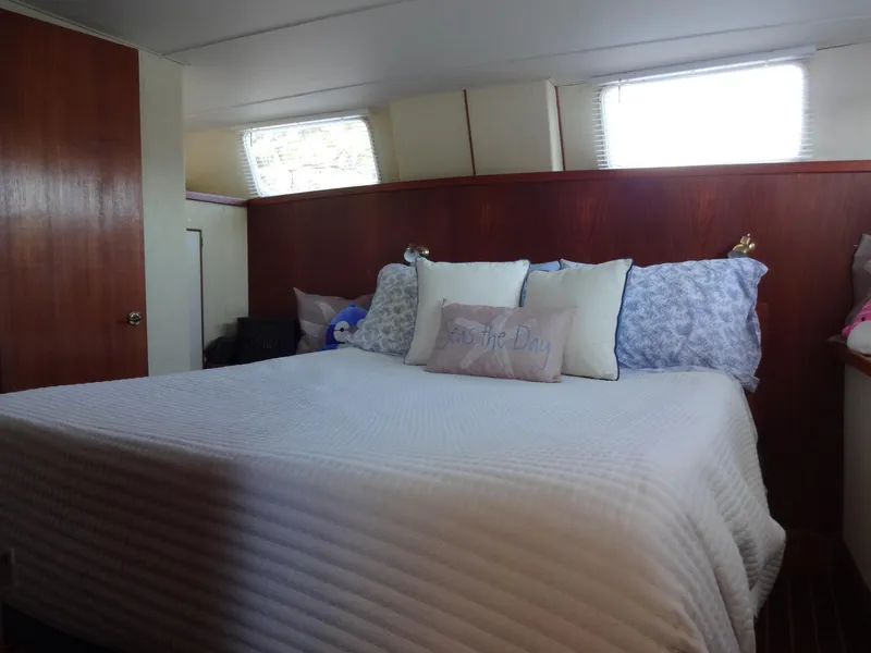 Slide: The Image of Cozy bedroom interior of 1986 Tollycraft 44 CPMY yacht with decorative pillows. - 49