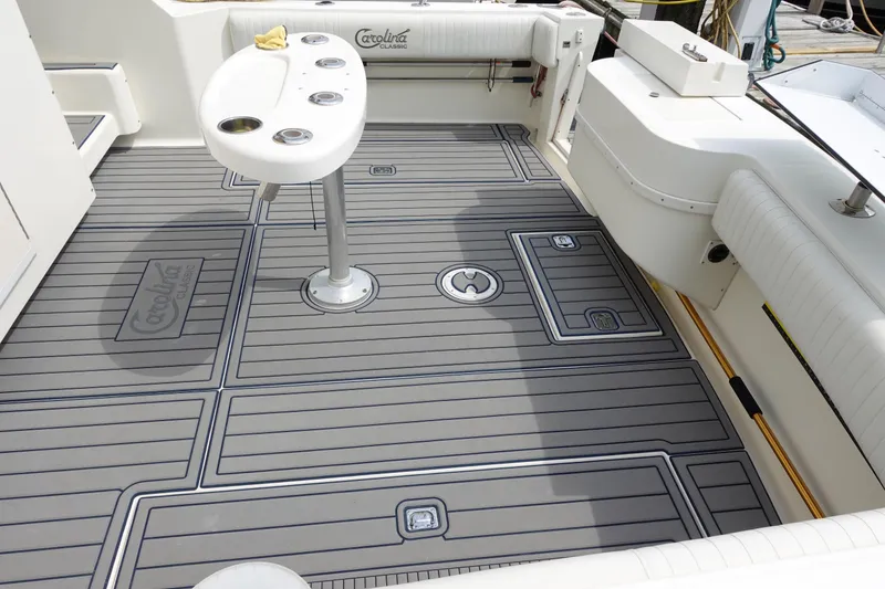 Slide: The Image of 2002 Carolina Classic 35 boat deck with gray non-slip flooring and fishing rod holders. - 11