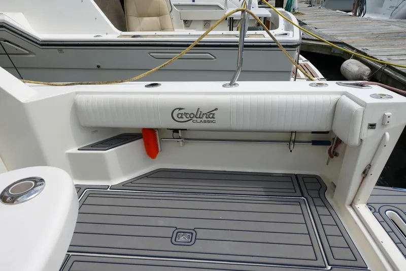 Slide: The Image of 2002 Carolina Classic 35 boat deck with logo, docked at marina. - 19
