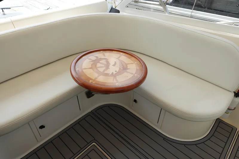 Slide: The Image of 2002 Carolina Classic 35 boat interior with curved seating and nautical-themed table. - 28